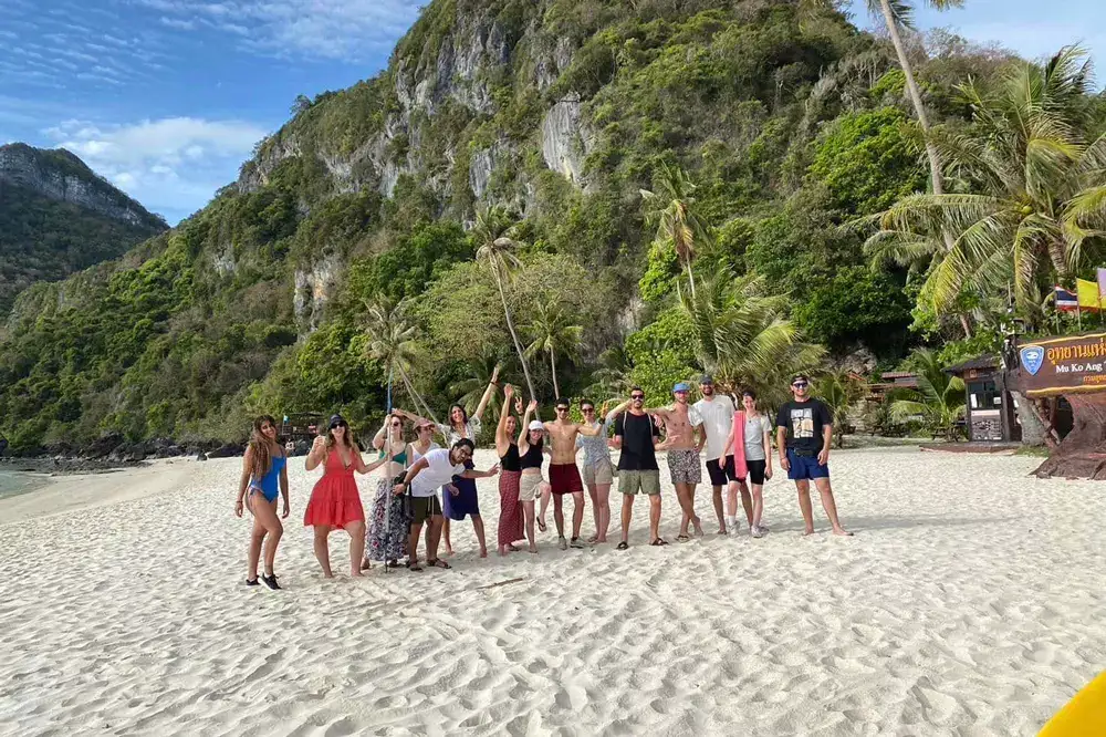 Small group on a white sand beach under the cliffs
