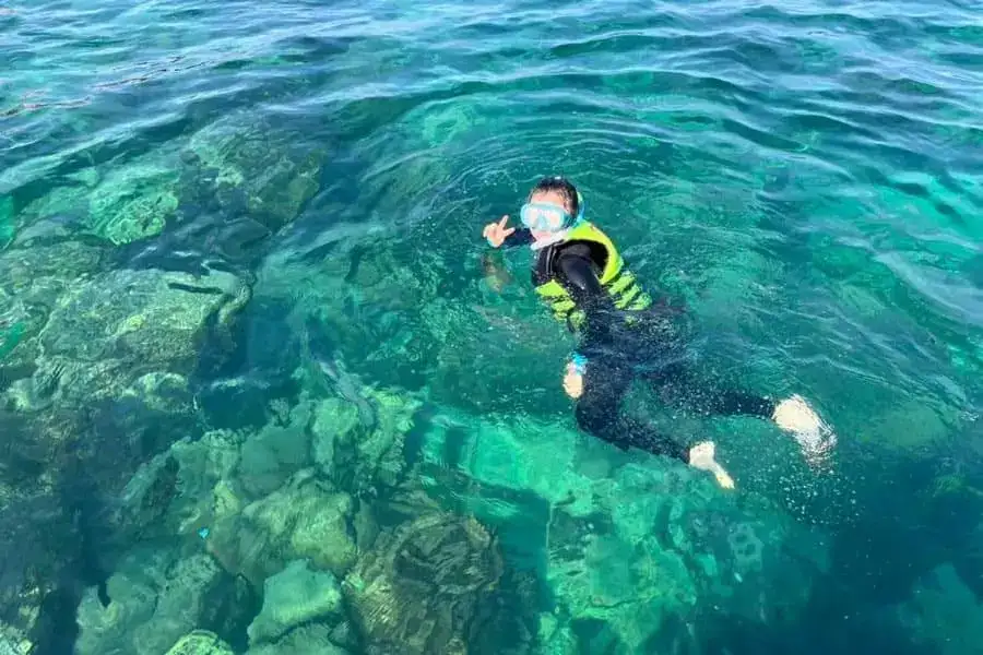 Snorkeler above a reef in clear water