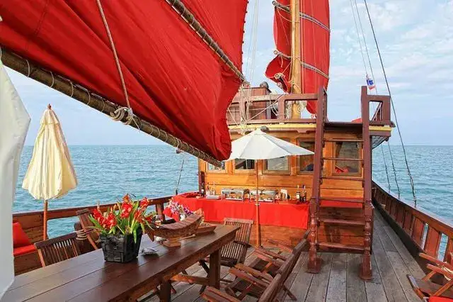 Ponte in teak con tavolo da pranzo e fiori