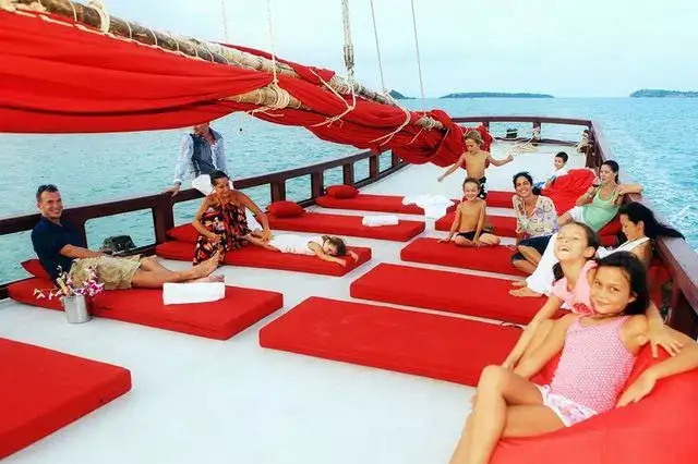 Ospiti che si rilassano sui cuscini rossi del solarium