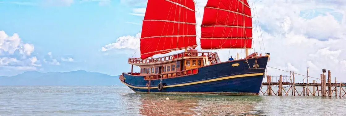La giunca a vela Red Baron con vele rosse e scafo blu scuro